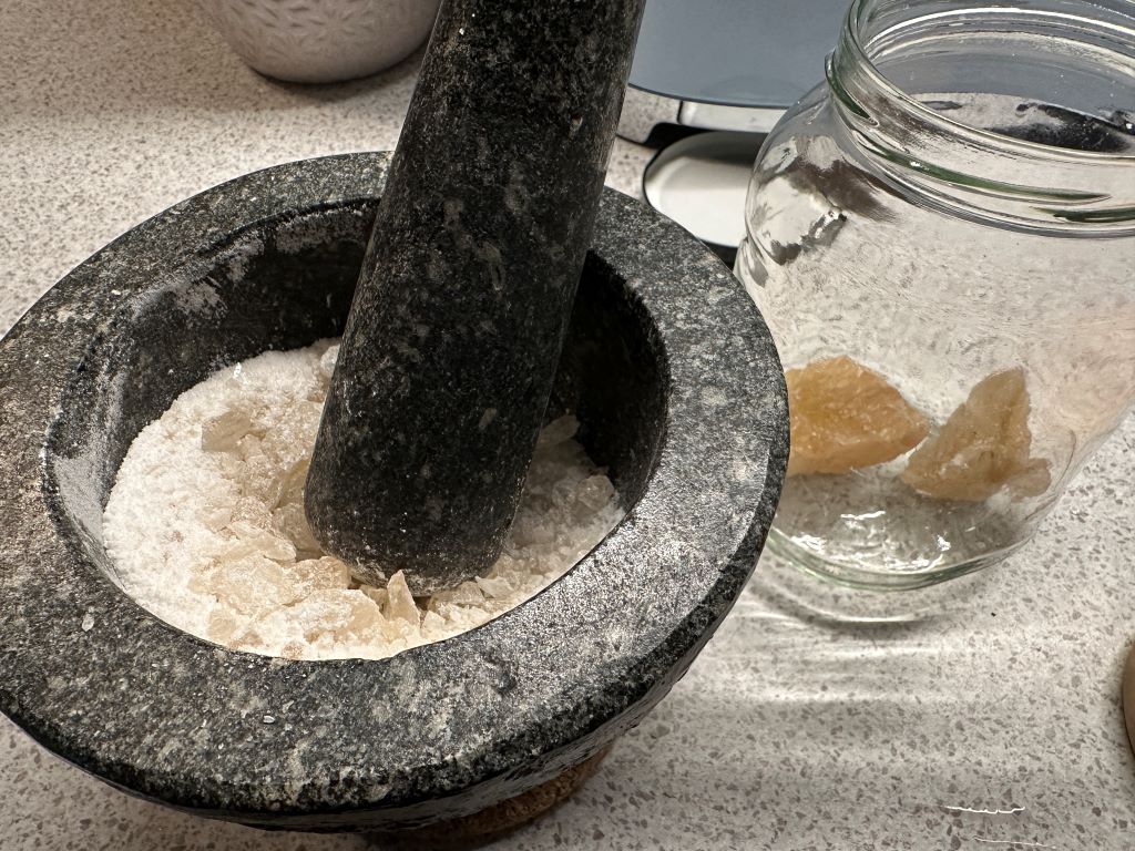 Grind rock sugar in mortar and pestle